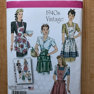 May include: Simplicity 1221 A vintage sewing pattern for 1940s aprons. The pattern features illustrations of women wearing different apron styles, with text indicating sizes S-L. The packaging is white with pink and red accents.