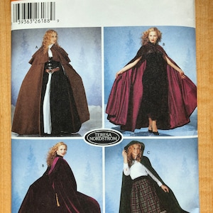May include: Simplicity sewing pattern number 5794 for a cape. The pattern includes three different styles: a brown cape with a high collar, a burgundy cape with a low collar, and a green cape with a hood. The pattern is for sizes XS, S, M, and L.