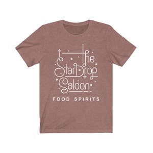 May include: A short-sleeved, mauve t-shirt with the white text "The StarDrop Saloon" and the words "FOOD SPIRITS" below. The design features stylized lettering and decorative elements.