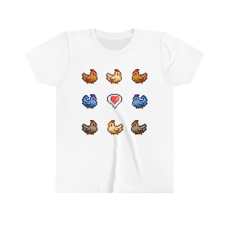 Pu&ograve; includere: Maglietta bianca con un design a pixel di nove galline e un cuore rosso. Le galline sono marroni, bianche e blu.