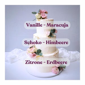 Może przedstawiać: Trzywarstwowy tort ślubny ozdobiony różowymi i białymi kwiatami oraz listkami złota. Warstwy tortu są oznaczone smakami: Vanille - Maracuja, Schoko - Himbeere i Zitrone - Erdbeere.