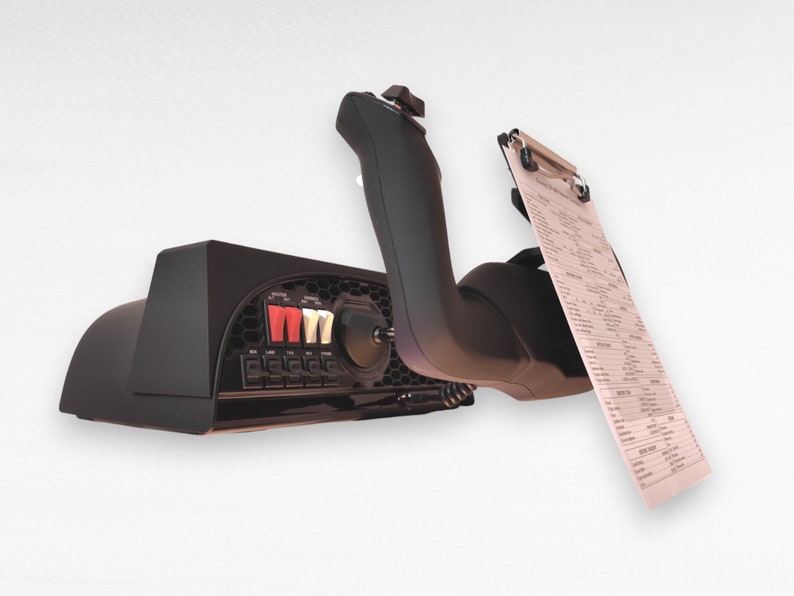 May include: Black flight simulator control panel with a variety of buttons and switches. A black joystick is attached to the panel and a clipboard with a checklist is attached to the joystick.