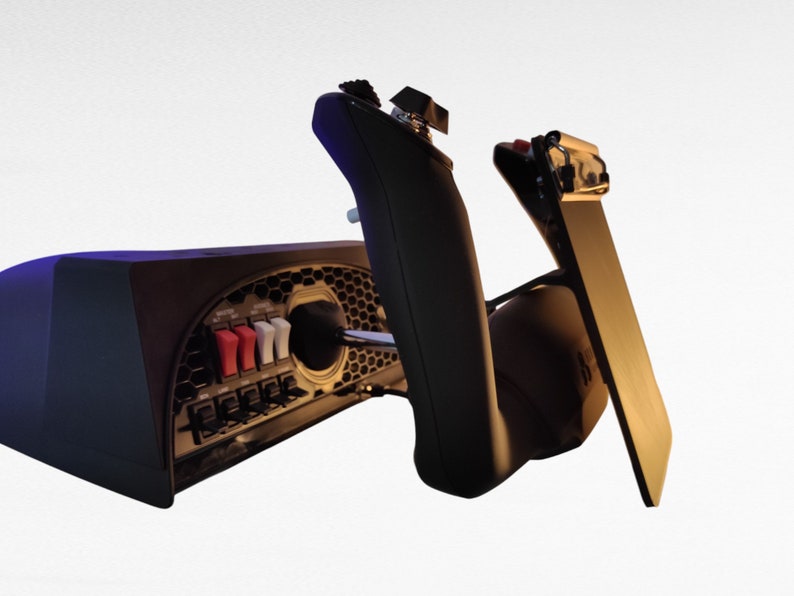 May include: A black gaming controller with a variety of buttons and switches. The controller is connected to a black base with a honeycomb pattern. The base has a red and white switch and a black lever.