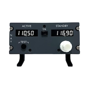 Può includere: Una radio di navigazione aerea grigia con un display digitale che mostra "110.50" e "116.90". La radio ha un pulsante "TEST" e una manopola. La radio è etichettata "ACTIVE" e "STANDBY".