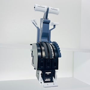 May include: A black and gray aircraft engine control panel with two white levers labeled "DISENGAGE" and a lever labeled "SPD BRK". The panel also has a black throttle with a silver gear, three black switches, and a black lever labeled "IDLE" and "CUT OFF".