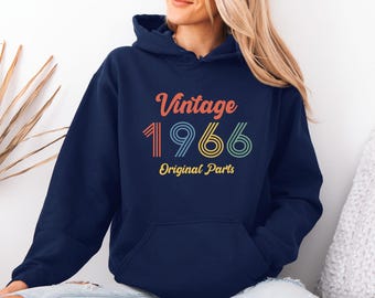 May include: A navy blue hooded sweatshirt featuring the text Vintage 1966 Original Parts printed on the front. The word Vintage is in orange, the number 1966 is in multi-coloured striped font, and the words Original Parts are in yellow.