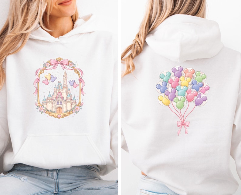 May include: White hooded sweatshirt featuring a pastel castle design framed by a pink ribbon and floral accents on the front. The back displays a cluster of colorful Mickey Mouse-shaped balloons tied with a pink bow. A cozy, casual top.