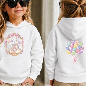 May include: White hooded sweatshirt featuring a colorful castle design on the front and a cluster of Mickey Mouse balloon graphics on the back. The front design includes a pink bow and floral accents. A comfortable and stylish garment for kids.