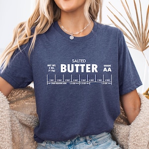 May include: A navy blue t-shirt with white text that reads "SALTED BUTTER AA" and includes a measurement guide for 4 oz (113g) of butter.