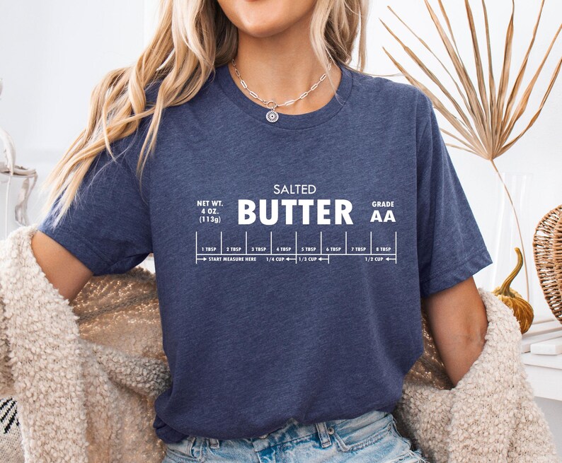 May include: A navy blue t-shirt with white text that reads "SALTED BUTTER AA" and includes a measurement guide for 4 oz (113g) of butter.