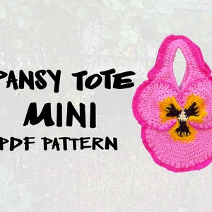 Może przedstawiać: Różowa torba na zakupy wykonana na szydełku w kształcie bratka. Torba ma żółto-czarne centrum i uchwyt. Tekst "PANSY TOTE MINI PDF PATTERN" jest napisany czarnym kolorem na białym tle.
