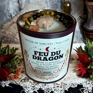 Könnte beinhalten: Ein burgunderfarbenes Kerzengefäß mit einem weißen Etikett, auf dem "Tresor de Sorciere | Magic Candle Feu du Dragon Revele ta puissance Allume la flamme du dragon Chasse les ombres, embrasse la lumiere! Bougie Cire de Soja Poids/250 G" steht. Das Gefäß ist mit einem Tigerauge-Stein-Armband und einigen orangefarbenen und braunen Steinen verziert.