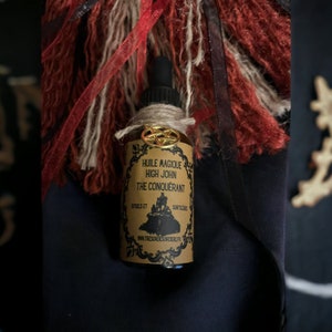 Peut inclure: Une bouteille en verre brun avec un charme pentagramme doré et une étiquette qui indique "Huile Magique High John The Conquerant Rituals et Sortileges www.tresorsdesorciere.fr"