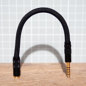 May include: A black braided cable with a right-angle 3.5mm jack on one end and a standard 3.5mm jack on the other end.