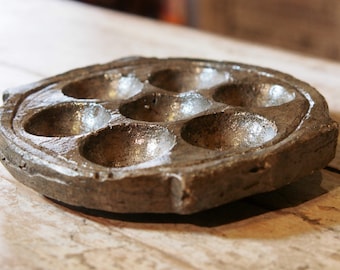 Puede incluir: Un plato de caracoles rústico, redondo, de cerámica marrón, con siete compartimentos individuales. El plato tiene una superficie texturizada y un borde ligeramente elevado. El plato de caracoles está diseñado para servir caracoles.