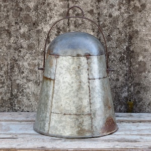 May include: A vintage galvanised metal bucket with a wire handle. The bucket is weathered and has a rustic look.