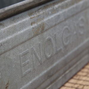 Può includere: Una cassetta in metallo zincato vintage con la parola "ENOLGAS" in rilievo sul lato.