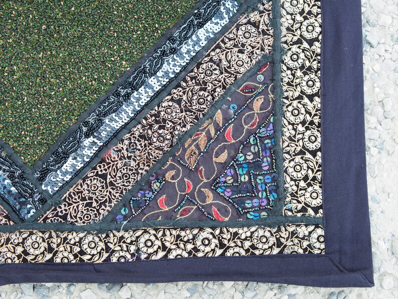 May include: A multi-colored patchwork fabric with a black border. The fabric is decorated with sequins, embroidery, and floral patterns.