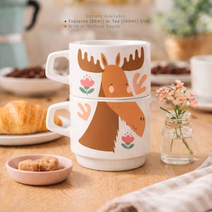 Pode incluir: Um conjunto de três canecas de cerâmica com acabamento fosco e salpicado. As canecas são em tons de creme, cinza claro e cinza escuro. Cada caneca tem um design simples e minimalista.