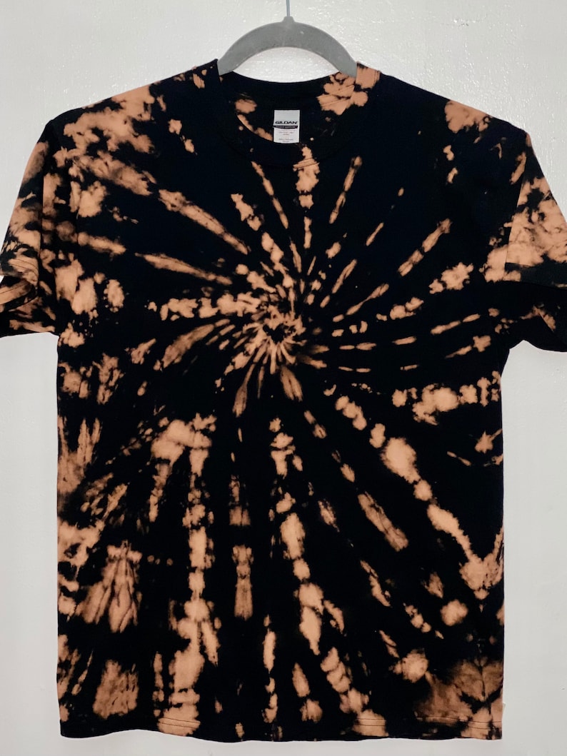 May include: Black t-shirt with a bleach tie-dye pattern in a spiral design.