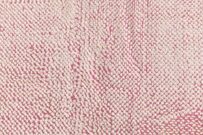 May include: Close-up of a pink and white textured fabric with a soft, fuzzy surface.