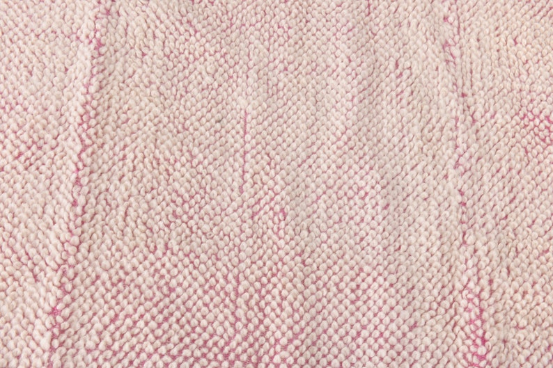 May include: Close-up of a pink and white textured fabric with a soft, fuzzy surface.