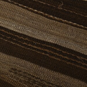May include: Close-up of a woven fabric with brown and beige stripes. The fabric has a textured surface and a diagonal pattern.