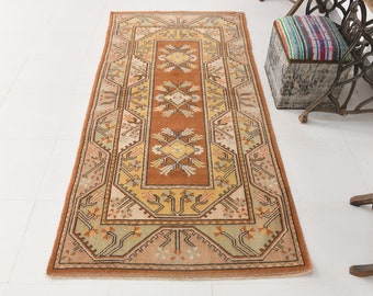 Könnte beinhalten: Ein antiker türkischer Teppich mit einem traditionellen geometrischen Muster in Braun-, Beige- und Grüntönen. Der Teppich ist rechteckig und hat einen Fransenrand.