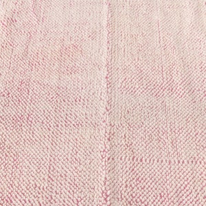 May include: Close-up of a pink and white textured fabric. The fabric has a soft, fuzzy texture.