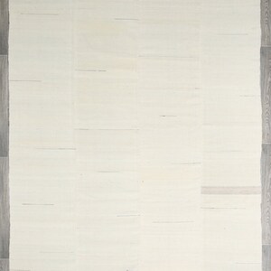 May include: A white woven rug with a subtle texture. The rug has a simple, minimalist design and is perfect for adding a touch of elegance to any room.