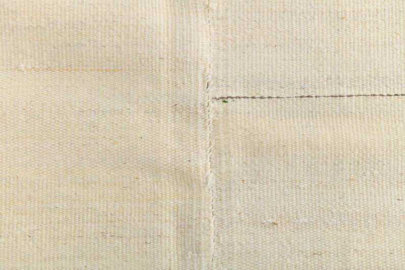 May include: Close-up of a white woven fabric with a seam running down the center.