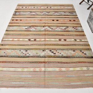 May include: A vintage striped rug with a muted color palette of beige, brown, pink, and gray. The rug has a woven design with geometric patterns.