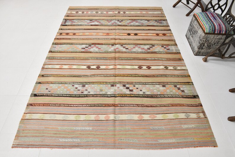 May include: A vintage striped rug with a muted color palette of beige, brown, pink, and gray. The rug has a woven design with geometric patterns.
