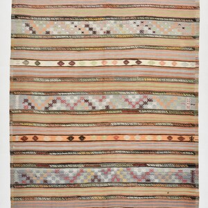 May include: A vintage rug with a striped pattern in shades of pink, beige, gray, and brown. The rug has a geometric design with small, repeating motifs. The rug is 8.5 feet by 5.9 feet.