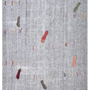 May include: A gray rug with a textured surface and scattered colorful shapes. The rug features red, brown, and beige shapes, along with small accents of yellow, pink, and blue. The rug measures 10.0 x 7.3 ft.