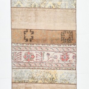May include: A vintage Turkish kilim rug with a beige background and colorful geometric patterns. The rug is made of wool and has a hand-woven texture.