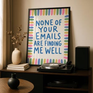 Pode incluir: Uma impress&atilde;o art&iacute;stica emoldurada com o texto azul NONE OF YOUR EMAILS ARE FINDING ME WELL num fundo creme. A impress&atilde;o &eacute; rodeada por uma borda colorida de tra&ccedil;os verticais em tons de rosa, amarelo, verde e azul.