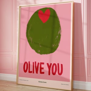 May include: A framed art print featuring a large green olive with a red heart on a pink background. Bold red text reads "OLIVE YOU". Below the text are the words "Green Love" and "Modern Art Collection".