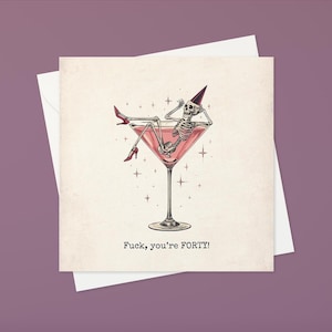 May include: Greeting card with a humorous illustration of a skeleton relaxing in a pink martini glass, wearing a party hat and red high heels. The text "Fuck, you're FORTY!" is printed below the image.