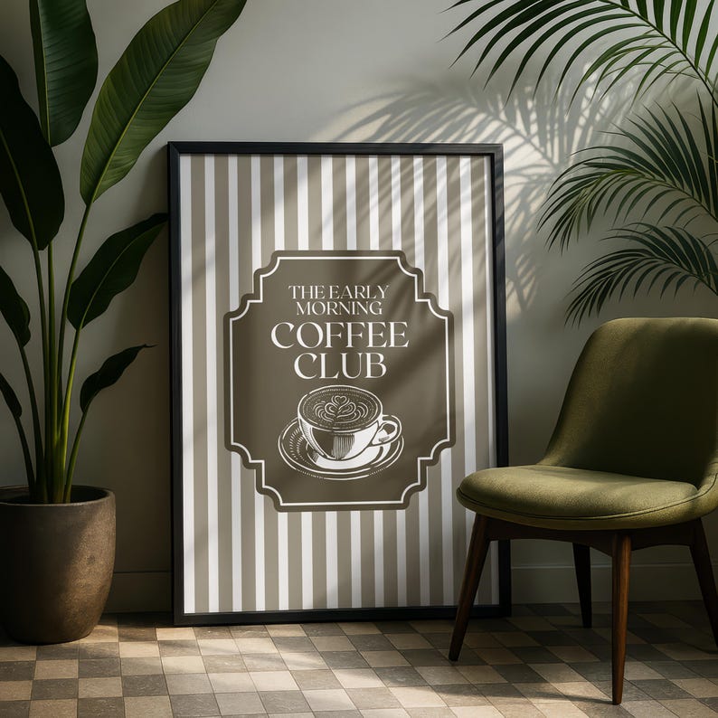May include: Framed wall art with a black border featuring a coffee-themed design. The artwork has a brown background with white vertical stripes. The text "THE EARLY MORNING COFFEE CLUB" is displayed above a coffee cup illustration.