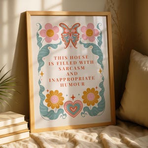 Könnte beinhalten: Holzgerahmter Kunstdruck mit dem Text "THIS HOUSE IS FILLED WITH SARCASM AND INAPPROPRIATE HUMOUR". Der Druck zeigt einen Schmetterling, Blumen und ein Herz in Rosa, Orange und Blau.