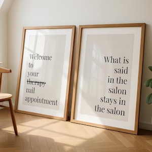 Könnte beinhalten: Zwei gerahmte Kunstdrucke mit hellen Holzrahmen. Ein Druck lautet "Welcome to your therapy nail appointment", der andere "What is said in the salon stays in the salon" in schwarzem Text auf cremefarbenem Hintergrund.