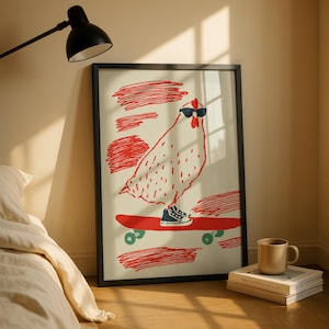 Op de afbeelding: Een ingelijste kunstprint met een lijntekening van een kip met een zwarte zonnebril en één sneaker op een rood skateboard. De illustratie bevat rode, krabbelachtige achtergrondaccenten op een crèmekleurige ondergrond in een zwarte lijst.