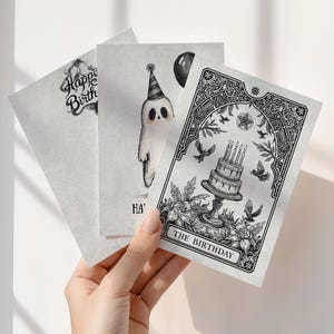 Puede incluir: Tres tarjetas de cumplea&ntilde;os con ilustraciones en blanco y negro. Una tarjeta dice "Happy Birth" con una fuente decorativa. Otra tarjeta presenta un fantasma con un gorro de fiesta. La tercera tarjeta dice "The Birthday" con una ilustraci&oacute;n de pastel.