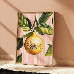 Peut inclure: Une impression encadrée d'un citron avec une texture de boule disco sur un fond rayé rose et blanc. Le citron est entouré de feuilles vertes.