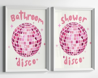 Könnte beinhalten: Zwei gerahmte Wandbilder mit rosa Discokugeln und weißen Sternakzenten. Der linke Druck zeigt den Text Bathroom disco in Rosa, der rechte Druck zeigt den Text shower disco in Rosa. Beide Drucke haben einen weißen Hintergrund.