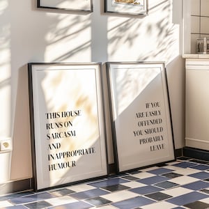 May include: Two framed wall art prints with black frames and white backgrounds. The left print reads: THIS HOUSE RUNS ON SARCASM AND INAPPROPRIATE HUMOUR. The right print reads: IF YOU ARE EASILY OFFENDED YOU SHOULD PROBABLY LEAVE in black text.