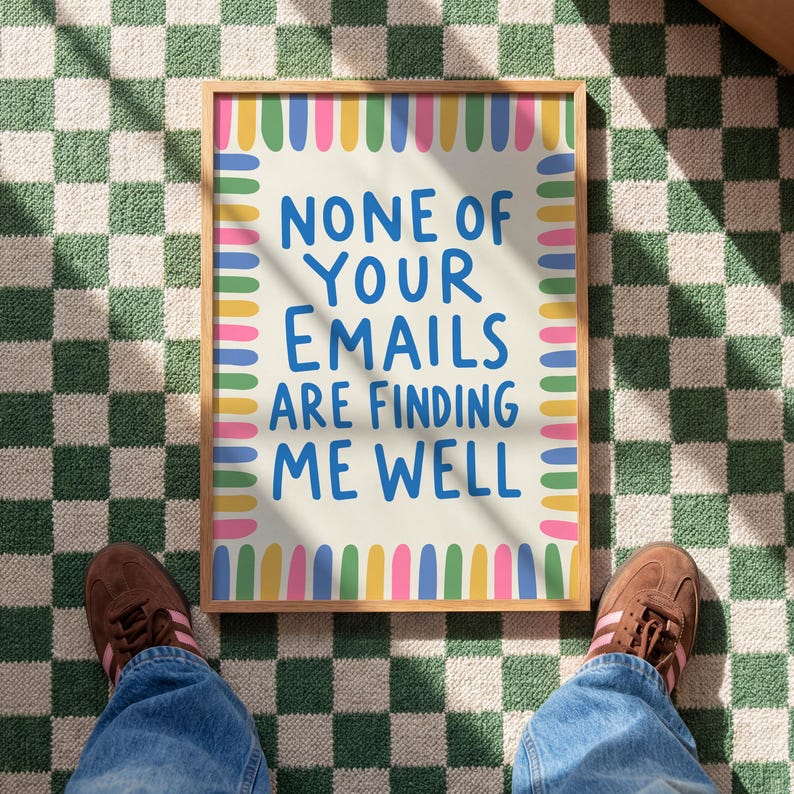 Pode incluir: Uma pe&ccedil;a de arte retangular emoldurada com um fundo creme claro e uma borda de tra&ccedil;os verticais coloridos em azul, amarelo, verde e rosa. O texto em azul diz: NONE OF YOUR EMAILS ARE FINDING ME WELL, centralizado numa fonte negrito sem serifa.