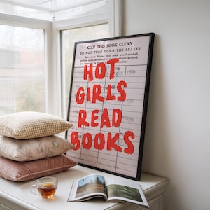 May include: A framed wall art print featuring a vintage library checkout card background with the text KEEP THIS BOOK CLEAN DO NOT TURN DOWN THE LEAVES and the bold red hand-lettered phrase HOT GIRLS READ BOOKS printed over the grid lines.