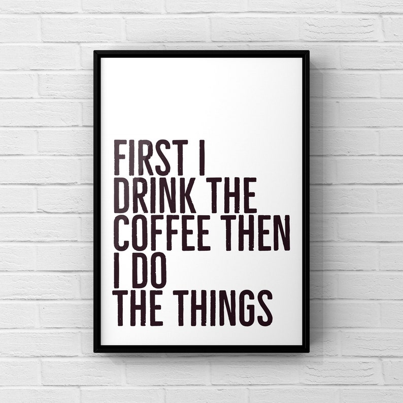May include: Black and white typography print with the text "First I drink the coffee then I do the things".